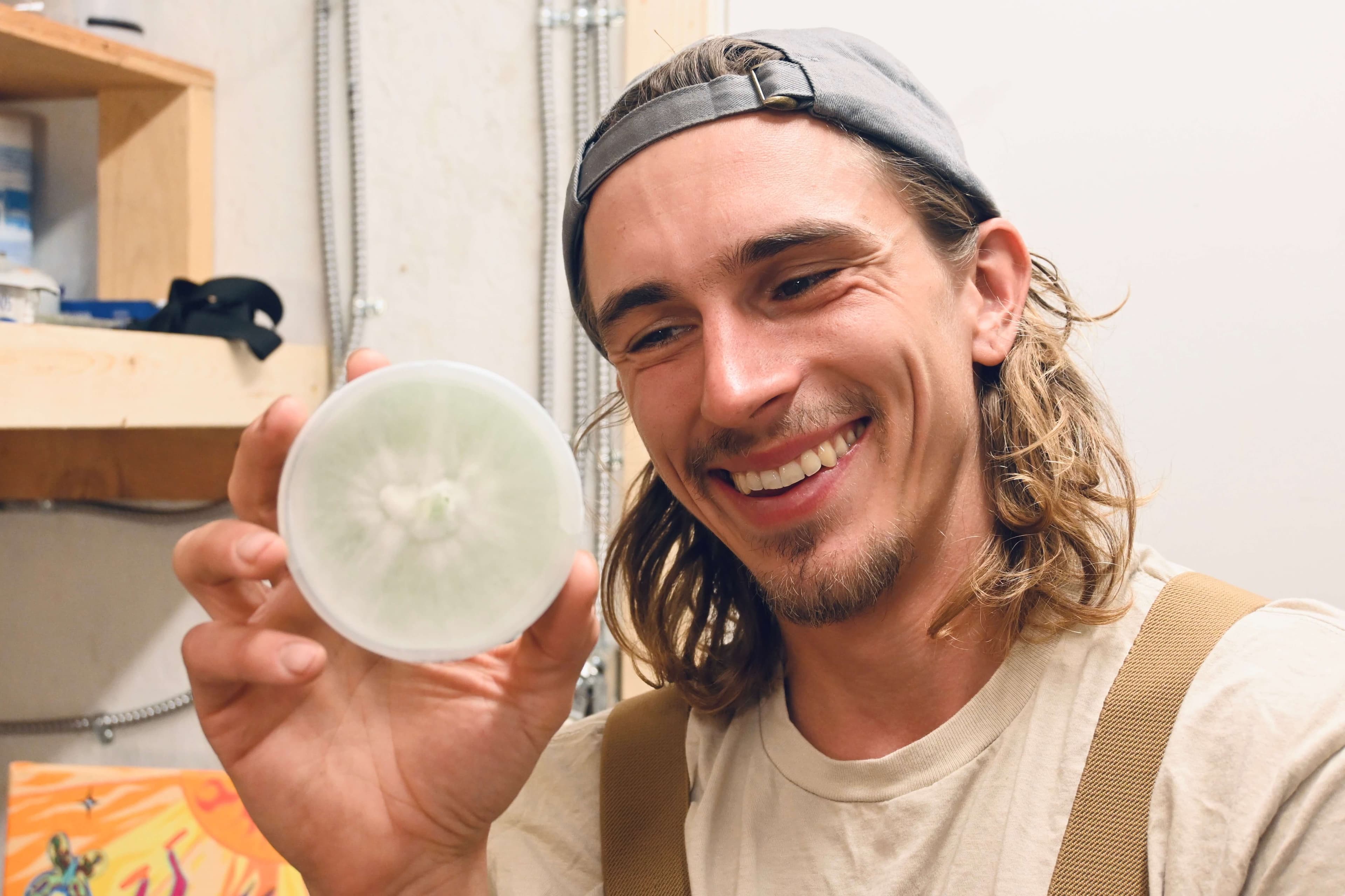 Jake holds a petri dish showing mycelium