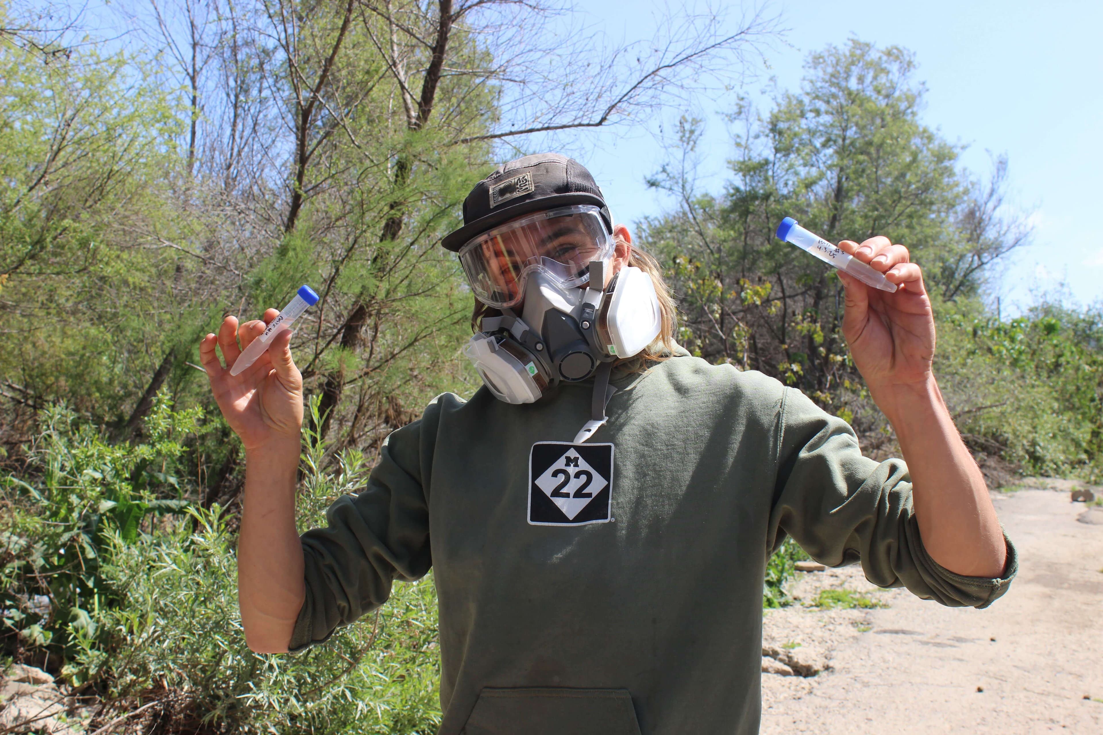 Jake sampling river water in protective gear